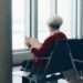 person in red coat sitting on chair